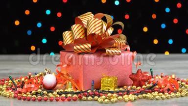 漂亮的圣诞礼品盒，上面有红色和<strong>金色条</strong>纹的蝴蝶结，木地板上有装饰，五颜六色的闪光